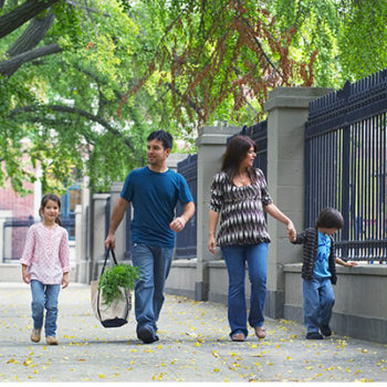 Family walking sidewalk neighborhood in