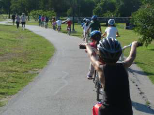Children ride in a straight line during a monthly bike ride. (Source: Dante Roll Models via Facebook)