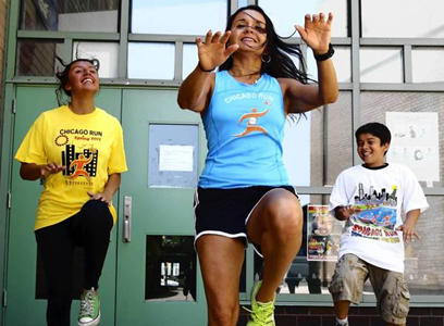 Alicia Gonzalez, executive director of Chicago Run, dances with two Chicago Run participants (Source: John J. Kim, Chicago Tribune, http://bit.ly/19U4Gxj )