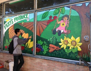 A youth admires the new mural he helped paint in front of Vicky's Produce to help better market healthy foods to customers. Source: https://www.facebook.com/Jovenessanoswatsonville
