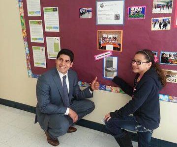 Praxina and city council member Rey Saldaña pose by a photo of the hydration station they would like to see installed at Five Palms. (Photo Source: Cathy Lopez)