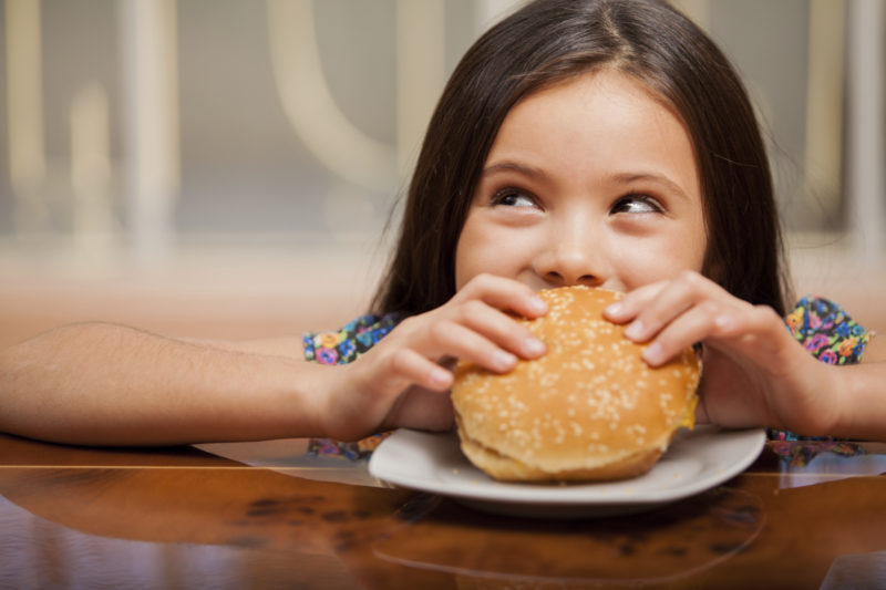 Girl eating a huge hamburger