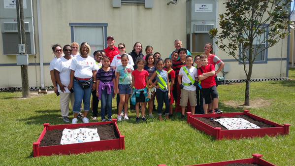 Students and teachers take photo with their new learning gardens. (Source: Courtney Johnson/UnitedHealthcare)