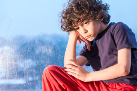 Bullying bullied, sad child sitting on a window