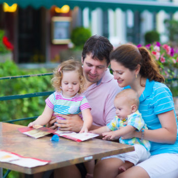 family looking at menu at restaurant outdoors