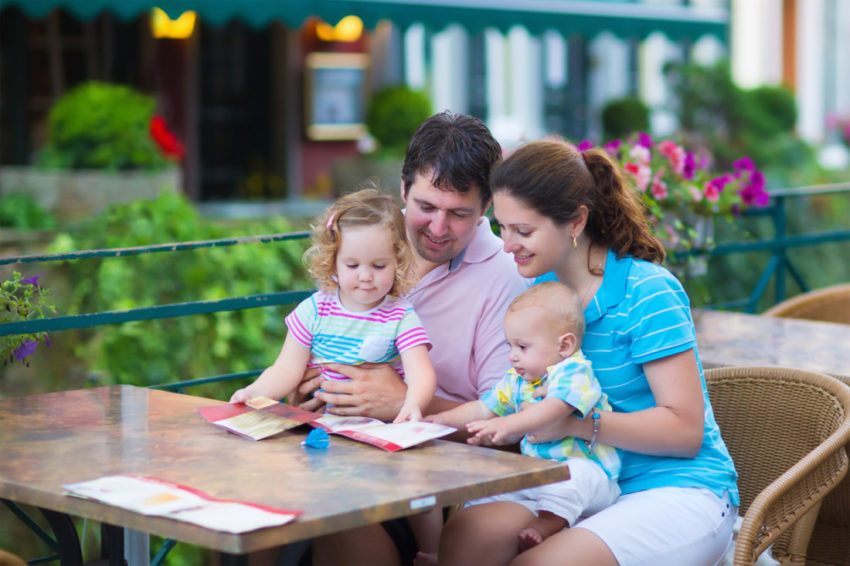 family looking at menu at restaurant outdoors