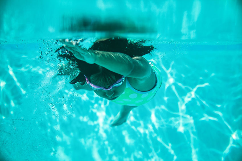 latino girl swimming in pool water
