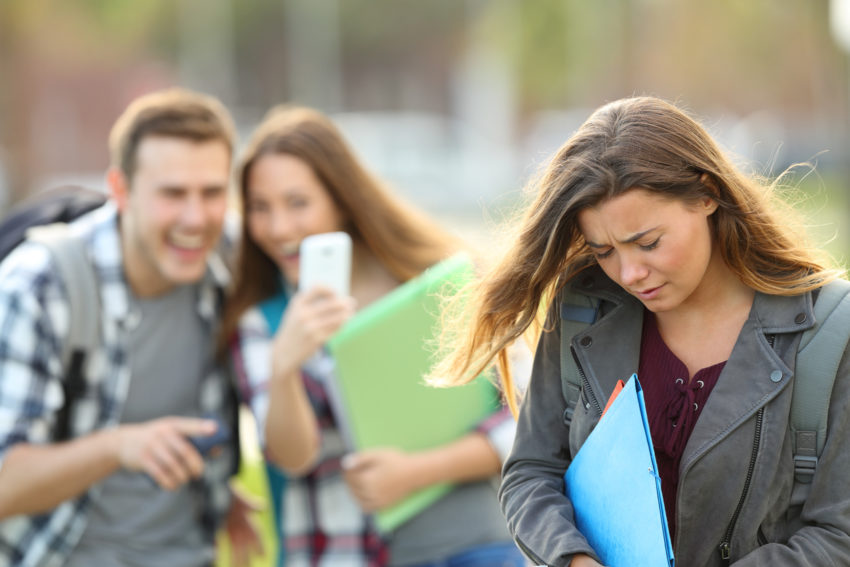 cyberbullying victim being video recorded on a smartphone by classmates discrimination latinos