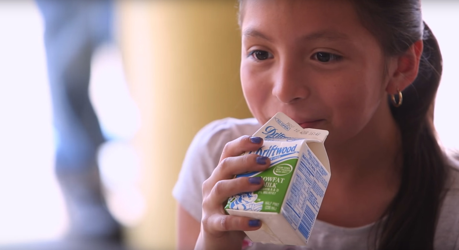 Latina girl drinsk white milk at school lunch or breakfast