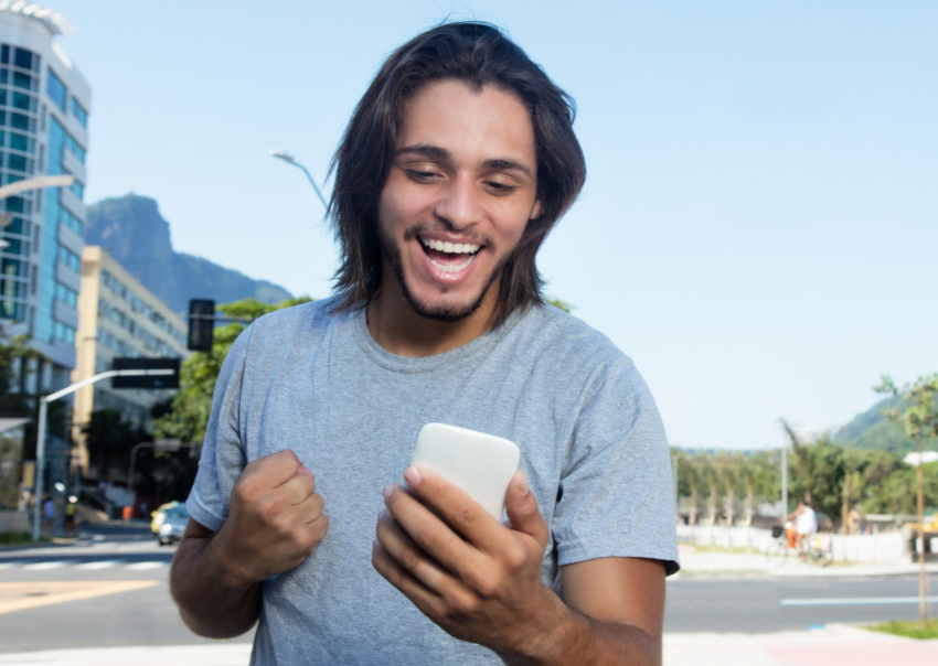 Hipster latino on phone looking confident happy
