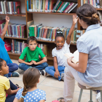 teacher and students reading taclking discussing raising hands