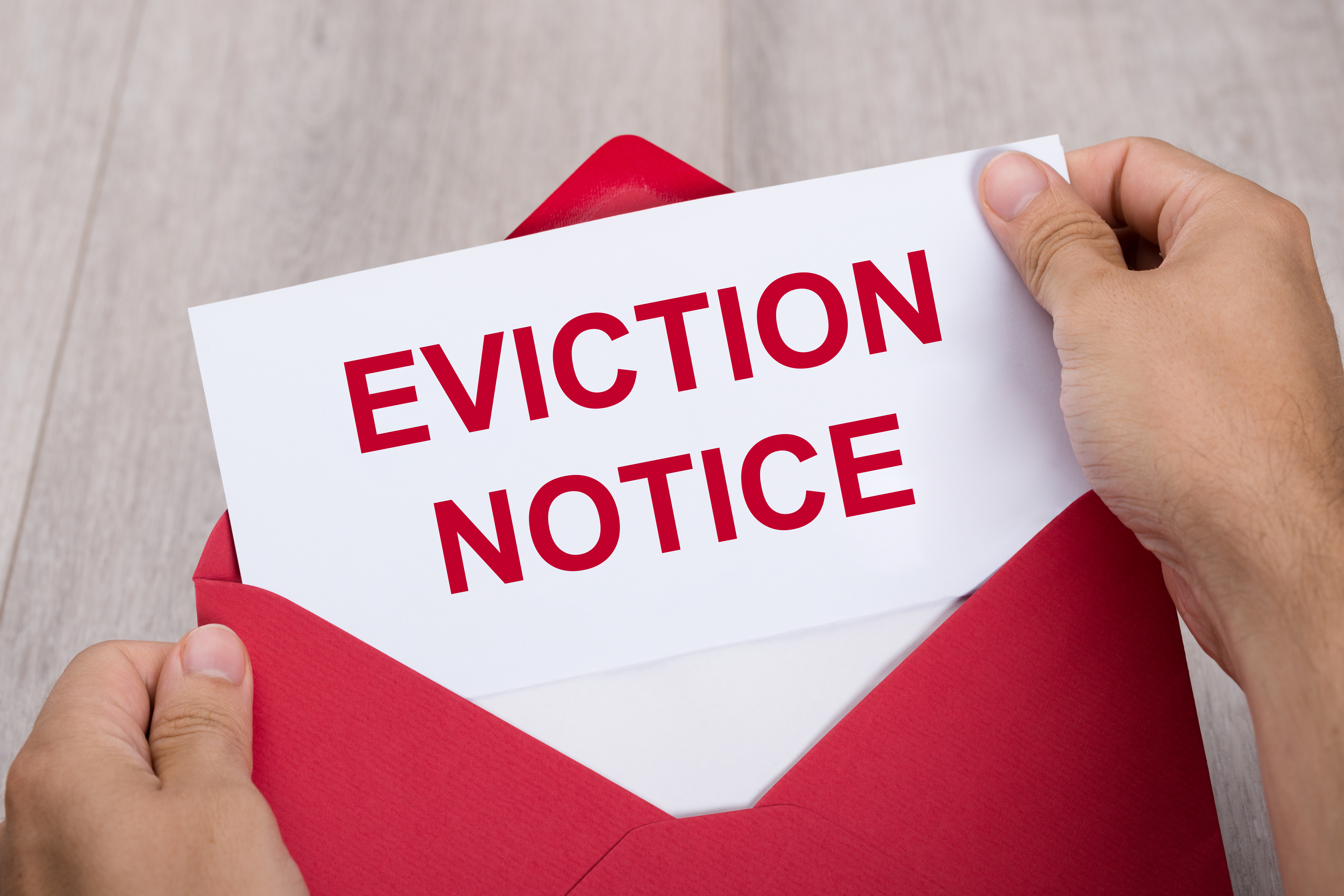 Hand Holding eviction notice in envelope