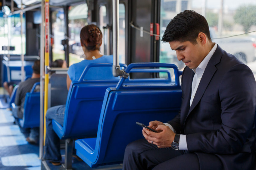Councilmember Rey Saldaña checks his phone to locate his current route on the bus Source Scott Ball Rivard Report