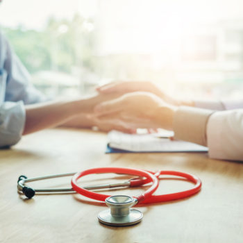 Doctor holding hands for comforting and care patient pediatric economic heath hardship