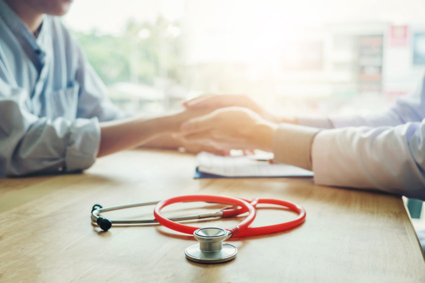Doctor holding hands for comforting and care patient pediatric economic heath hardship