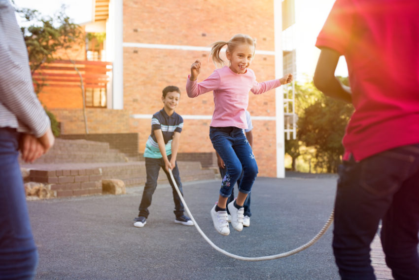 Children playing with skipping rope in elementary school health