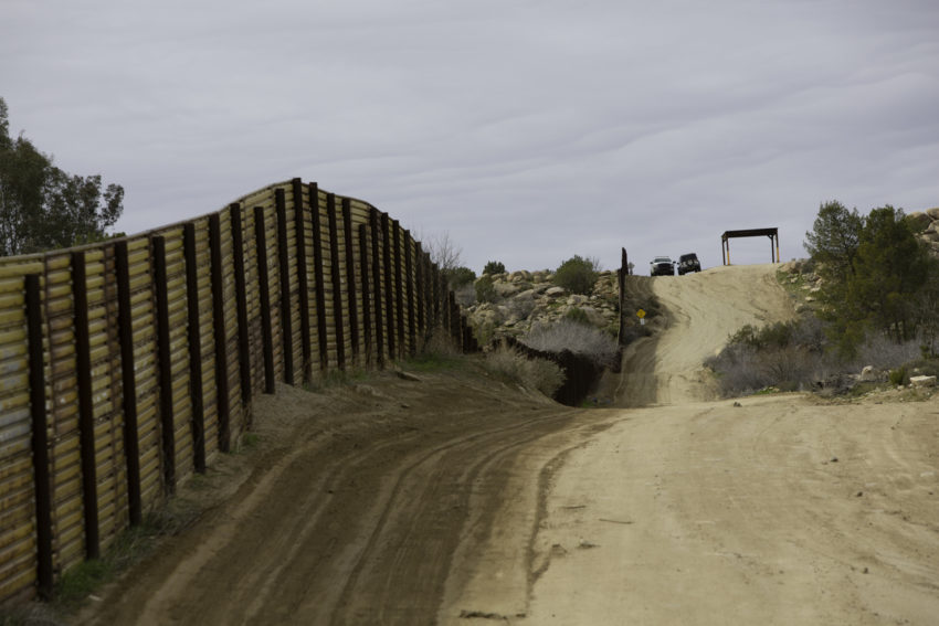 Border Patrol Vehicles Near Barrier Wall in California moral disengagement