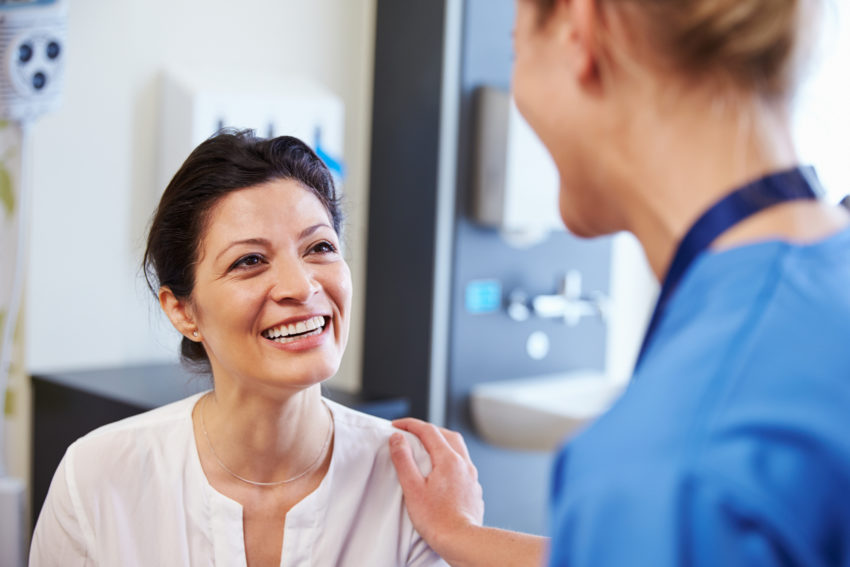 Latino cancer patient smiling with doctor nurse clinic