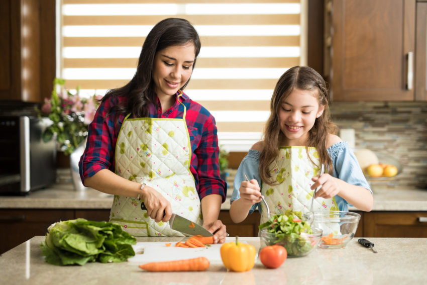 latina mom and daughter dietary guidelines nutrition food veggies cutting cooking