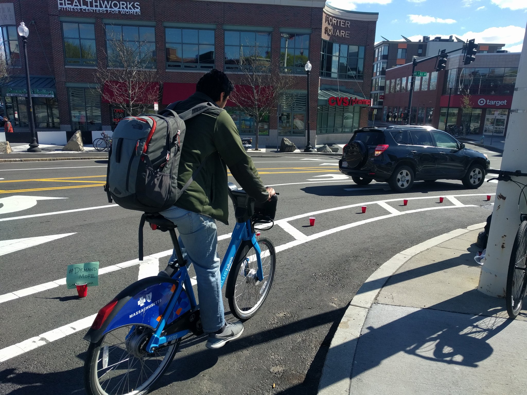 Cambridge Bicycle Safety place red cups between the travel lane and the bike lane on a dangerous curve. 