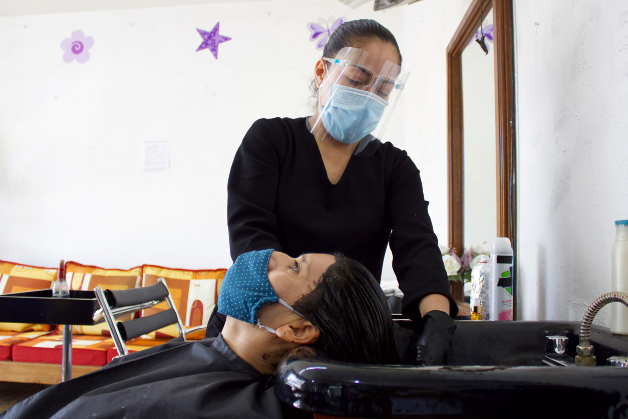 latina hair salon worker wearing face mask amid covid-19 coronavirus case