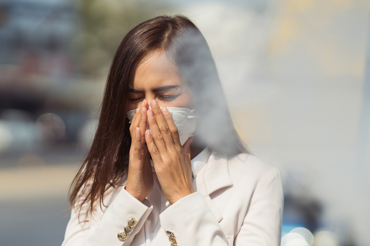 Woman coughing due to smoke smoke-free policy for indoor air mil gracias