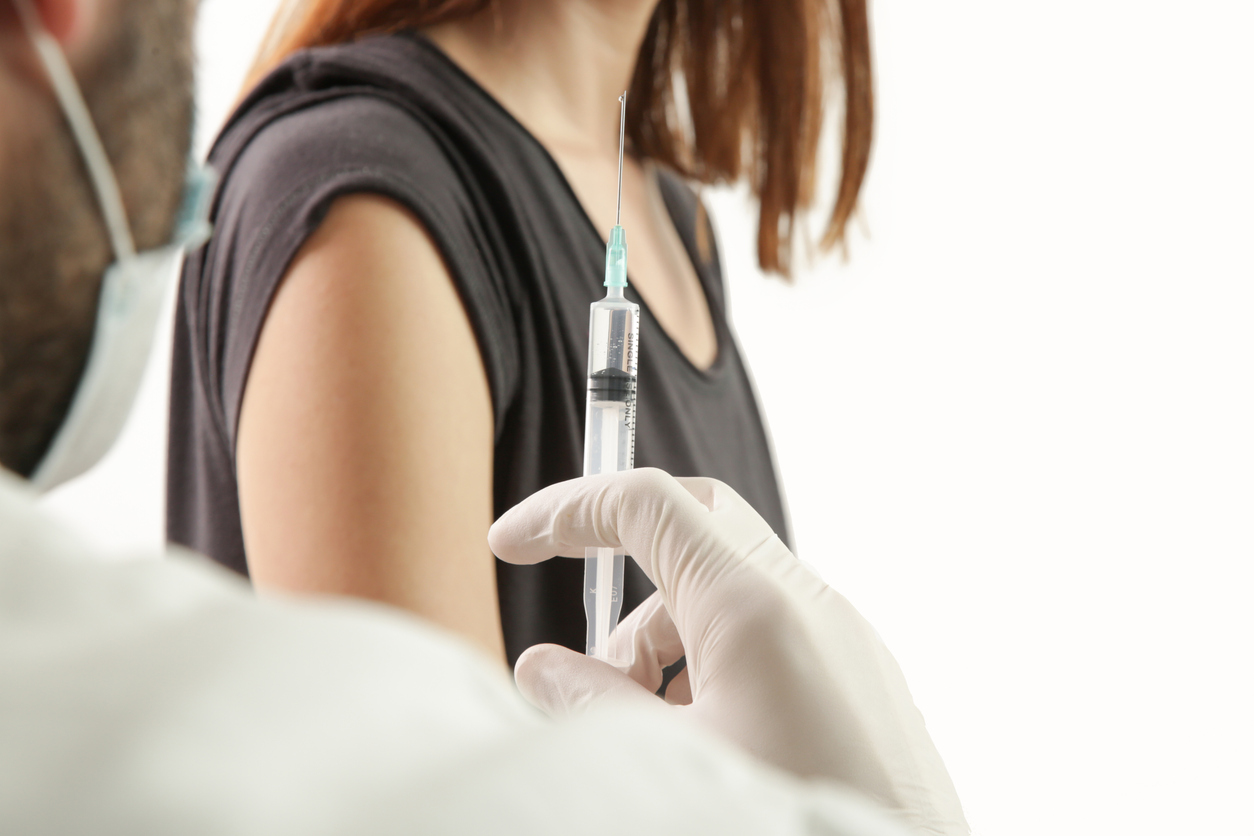 Doctor giving patient vaccine, flu or influenza shot or covid-19 vaccine
