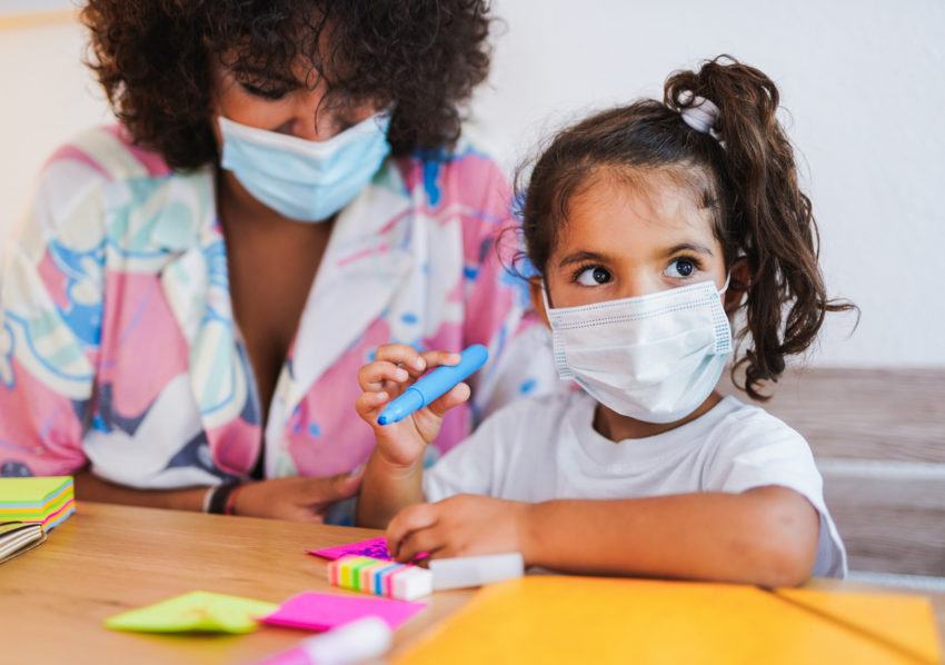 hispanic latino child girl student home coloring work wearing face mask amid COVID-19 coronavirus