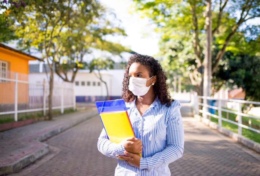 latina woman student with books face mask to prevent covid-19 coronavirus Hispanic-serving Institutions