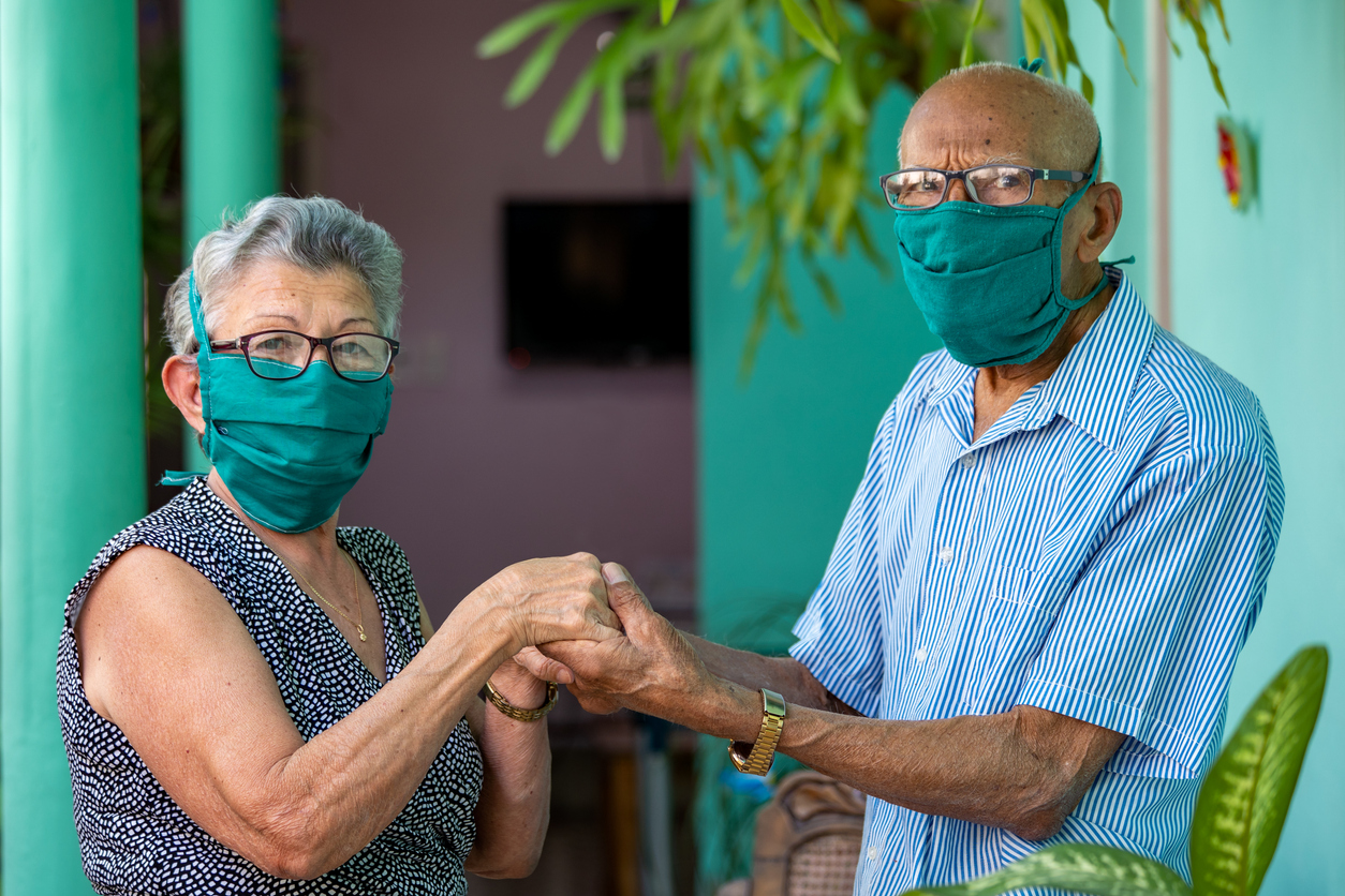 latino couple elderly wearing face masks to prevent covid-19 coronavirus dementia alzheimers