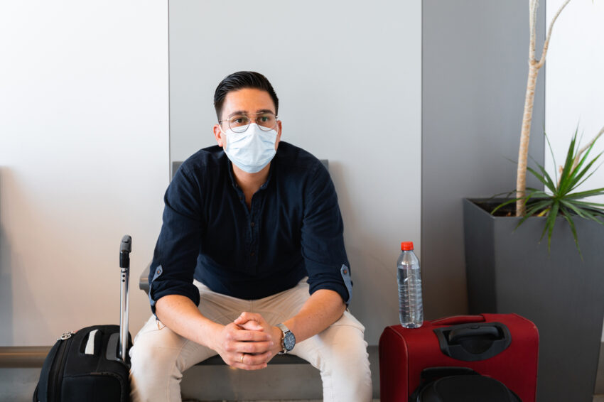 latino man at airport waiting face mask coronavirus covid-19