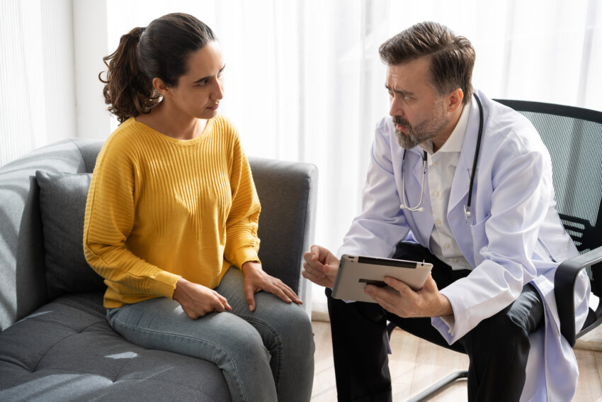 Patient Latin woman meeting Caucasian doctor at hospital