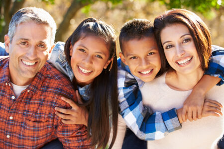 Happy Hispanic family outdoors in country