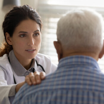 Trusted therapist support old man patient hold hand on shoulder