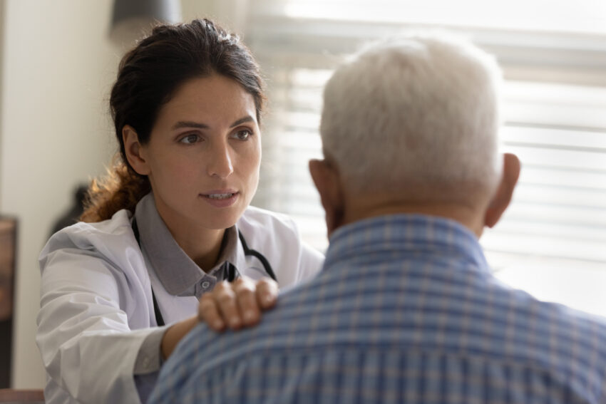 Trusted therapist support old man patient hold hand on shoulder