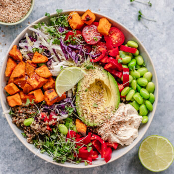 Colorful vegan bowl with quinoa, sweet potato, avocado, hummus and variety of veggies