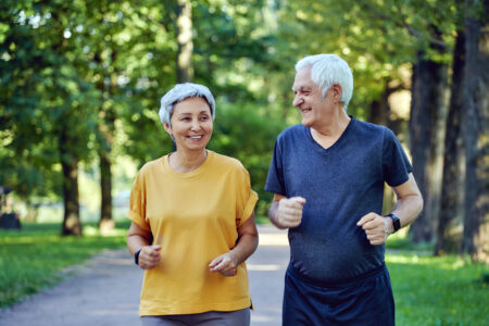 enior couple jogging in the summer park