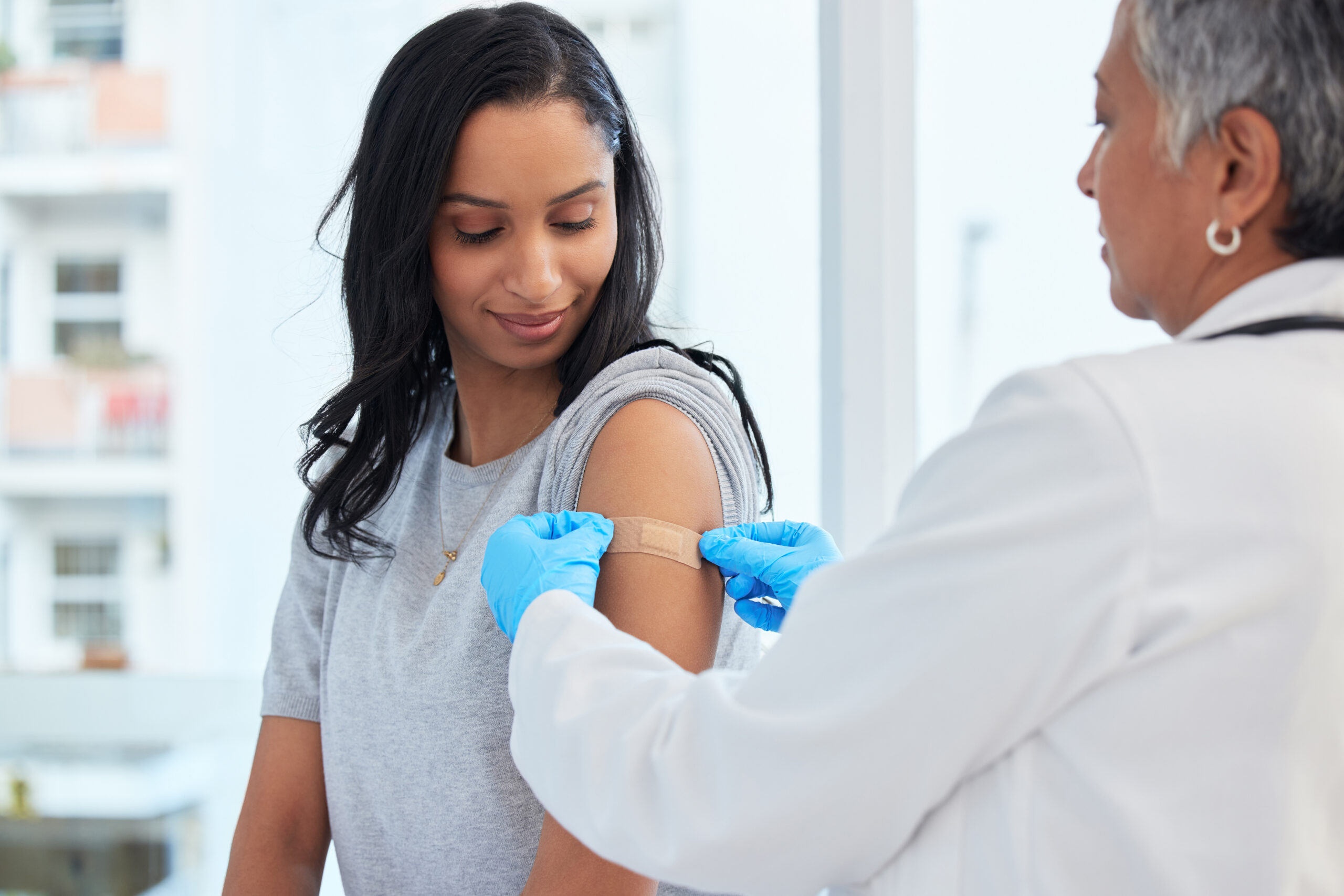 woman getting a bandage after getting a vaccine