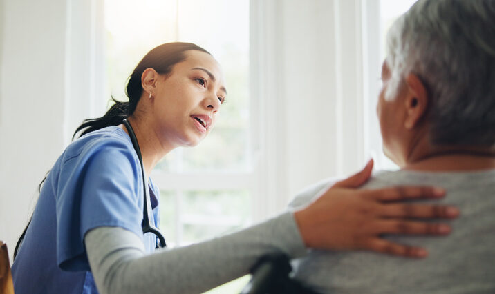 Woman, nurse and senior in wheelchair for support, elderly care or trust at old age home. Medical doctor or caregiver listening to person with a disability or consulting for health advice or help