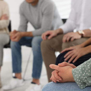 People at group therapy session indoors, closeup