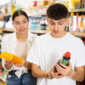 Couple in market reading labels on products.
