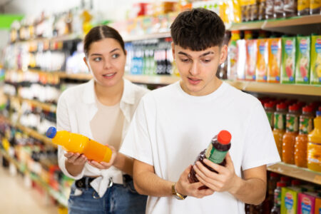 Couple in market reading labels on products.