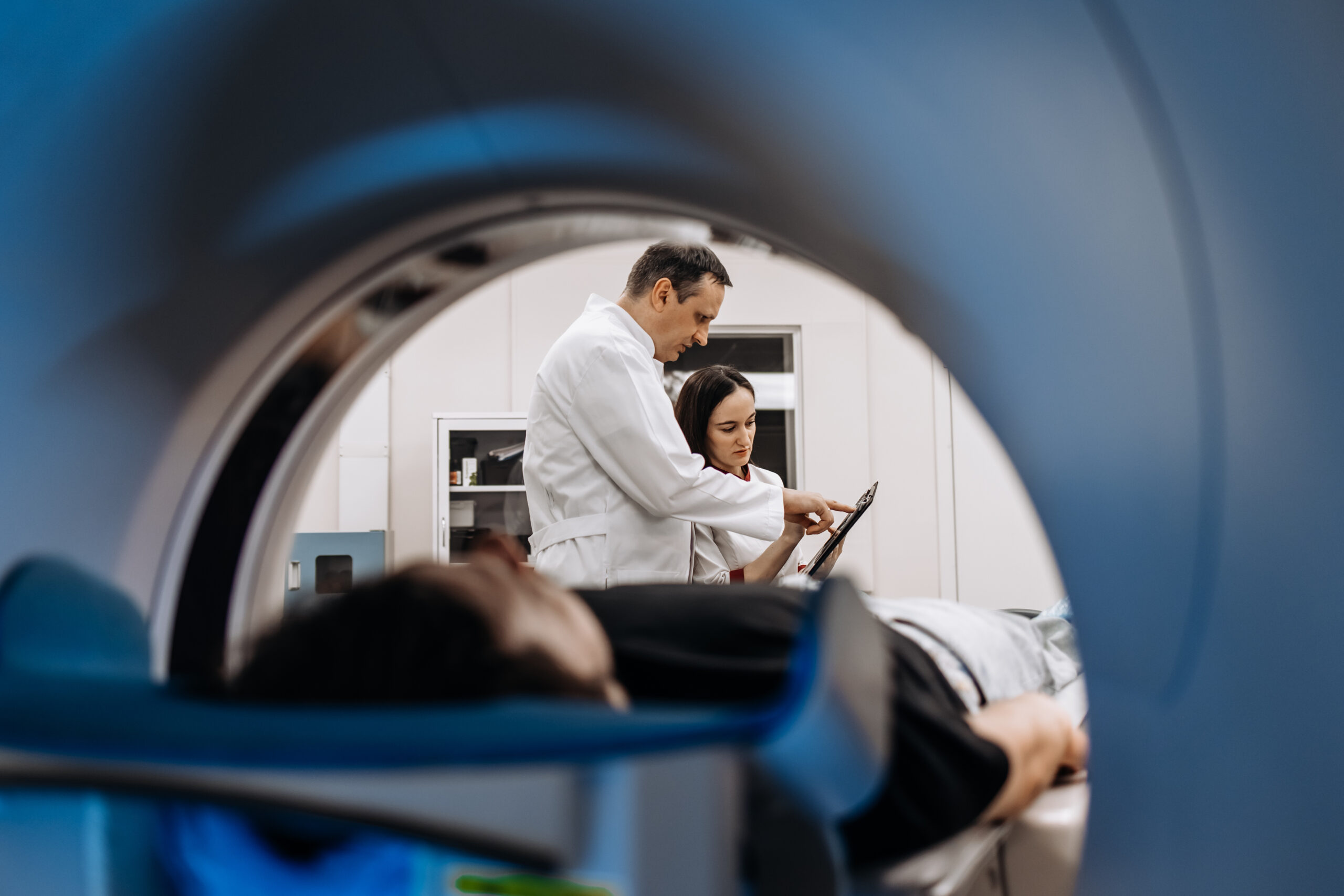 In a bright diagnostic center, a young man undergoes a CT or MRI scan using modern equipment. This image reflects the forefront of medical technology, emphasizing precision and patient care.
