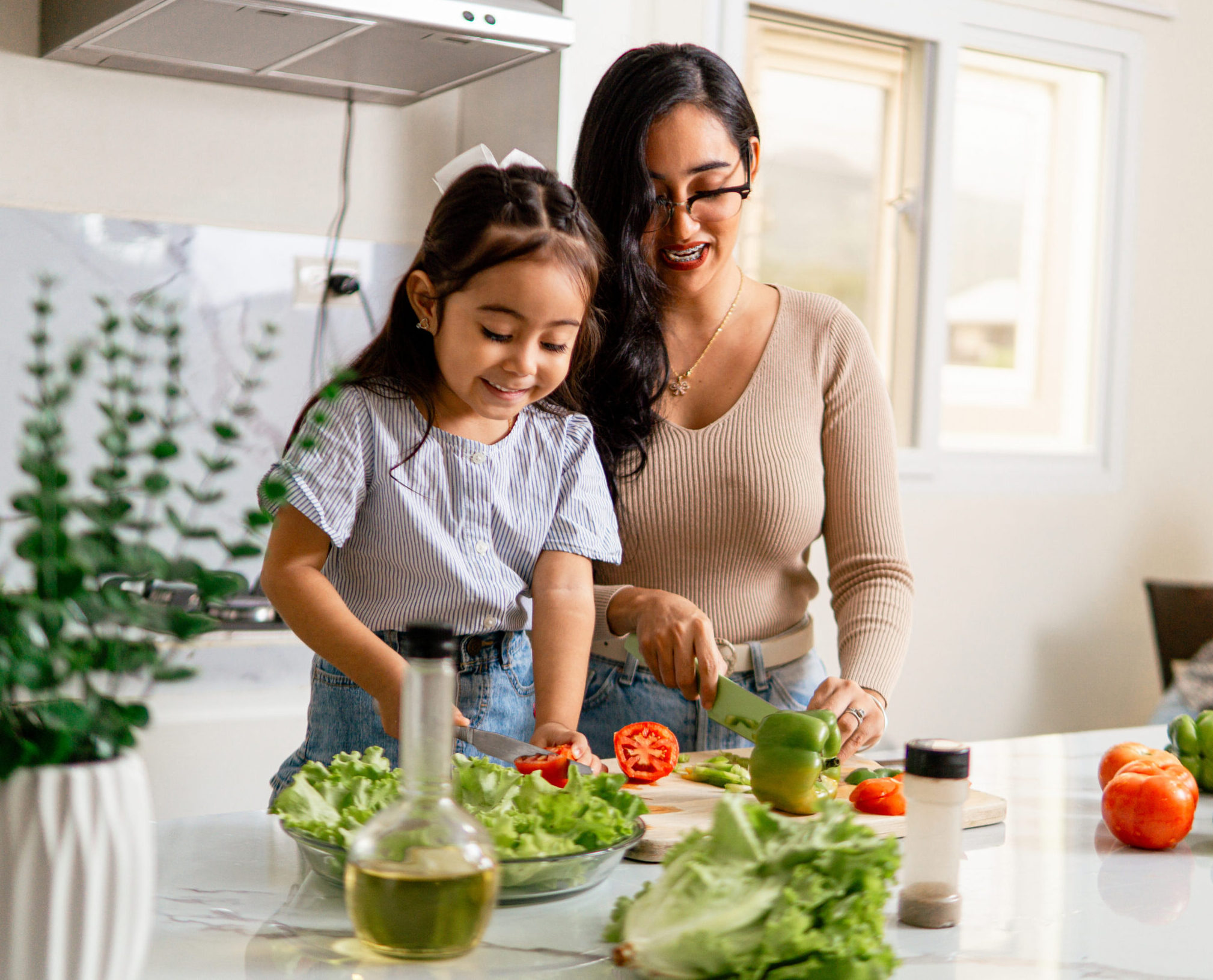 Mother and daughter happily preparing a healthy meal together.