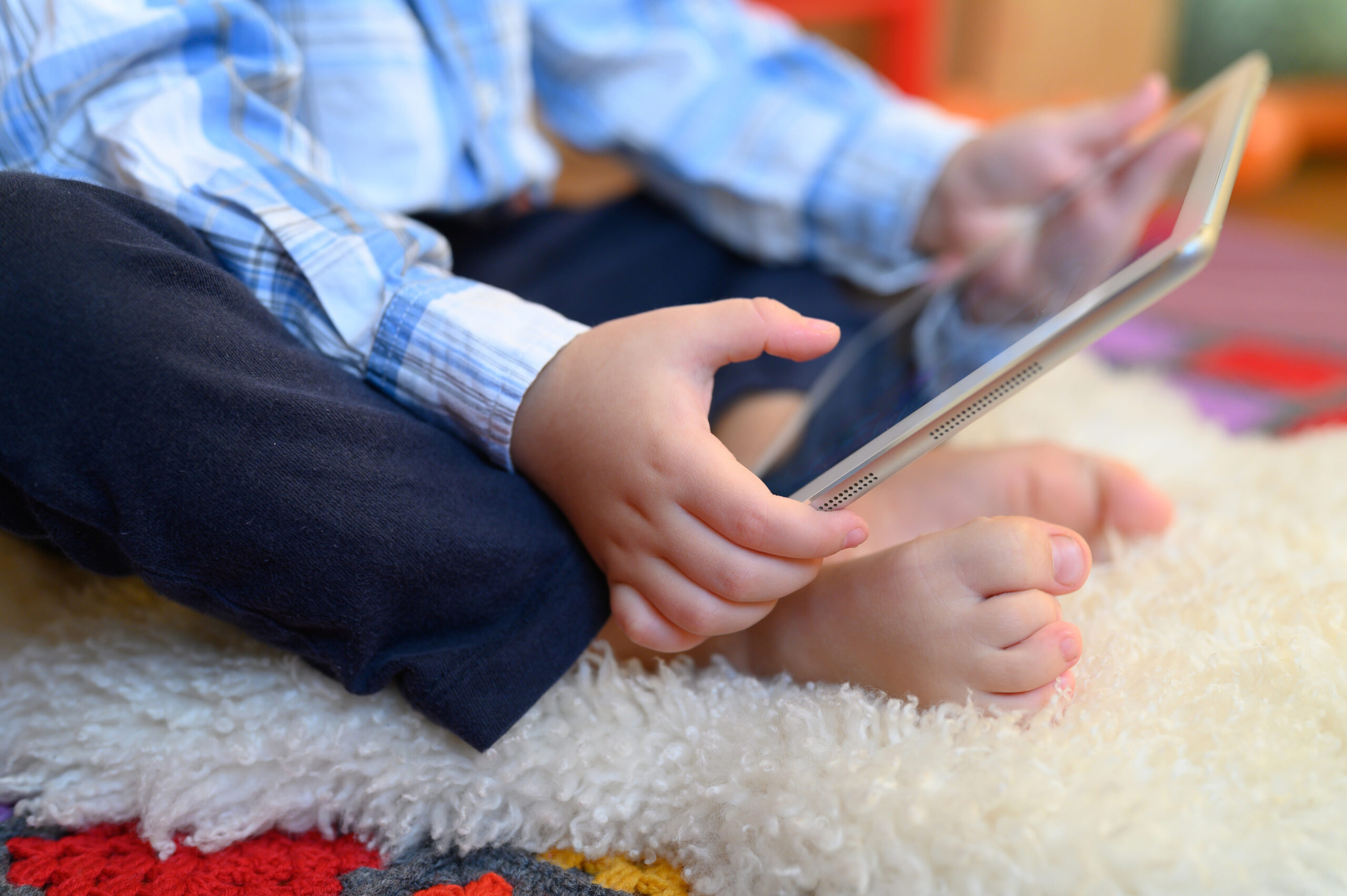 a little boy holds a tablet in his hands