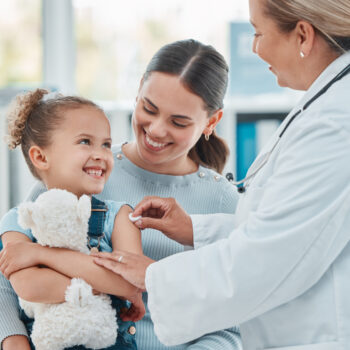 Shot of a doctor using a cotton ball on a little girl's arm while administering an injection in a clinic