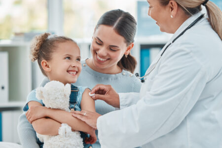 Shot of a doctor using a cotton ball on a little girl's arm while administering an injection in a clinic