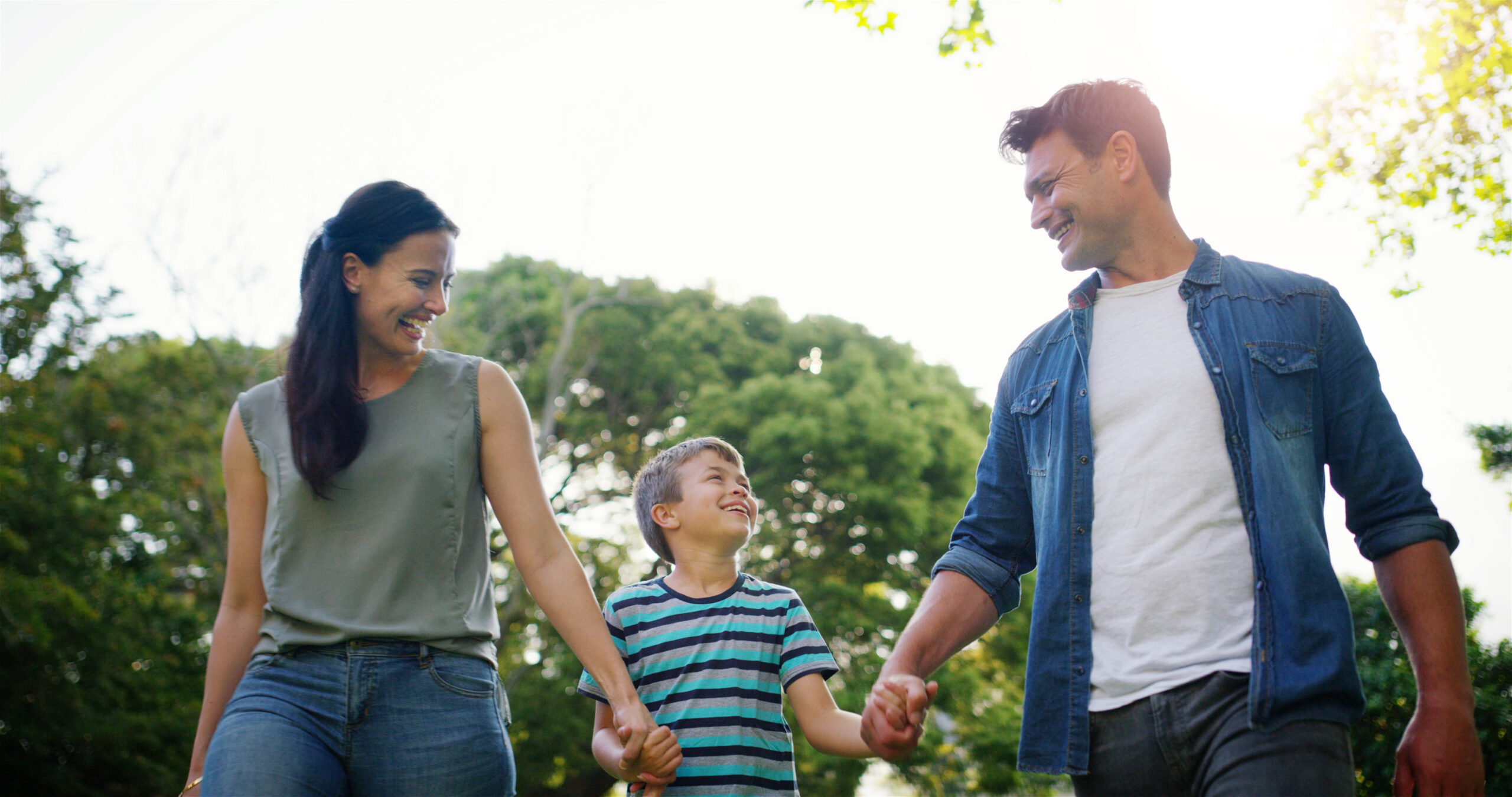 Latino parents walking with child.