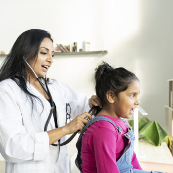 female doctor listening a little girl in hospital