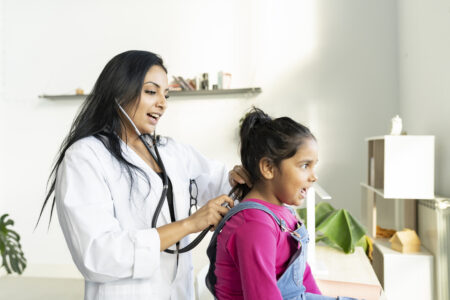 female doctor listening a little girl in hospital